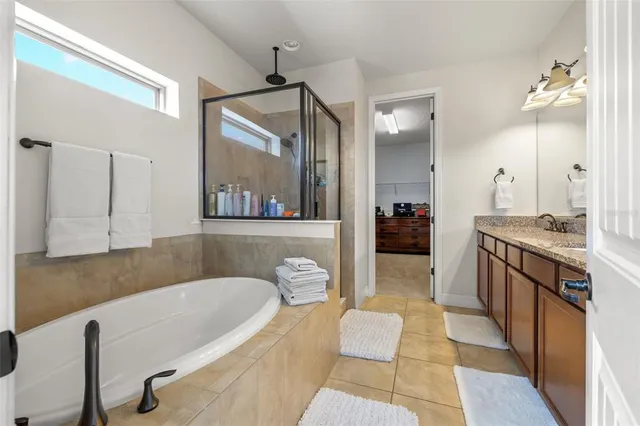 a bathroom with a tub a double vanity sink and a mirror