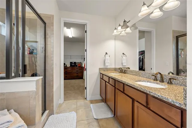 a bathroom with a granite countertop sink a light fixture and a mirror