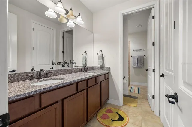 a bathroom with a granite countertop sink a toilet and shower