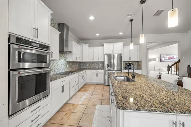 a large kitchen with kitchen island granite countertop a large counter top stainless steel appliances and cabinets