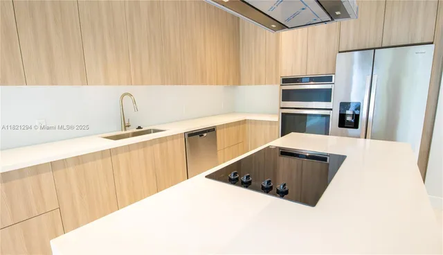 a kitchen with stainless steel appliances a white refrigerator freezer a sink and dishwasher