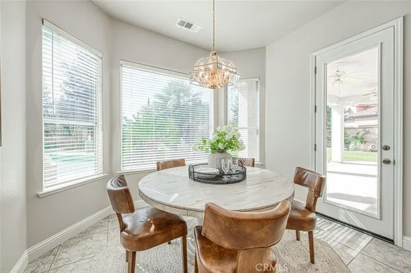 a dining room with furniture a chandelier and wooden floor