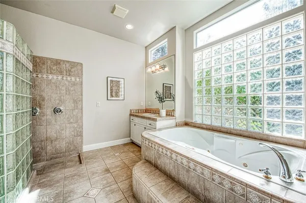 a spacious bathroom with a granite countertop tub sink and shower