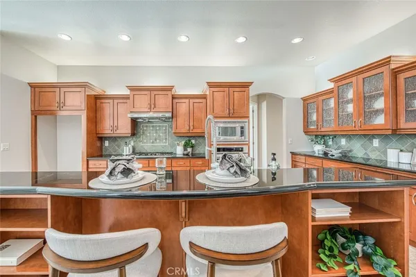 a room with stainless steel appliances granite countertop a sink and a cabinets