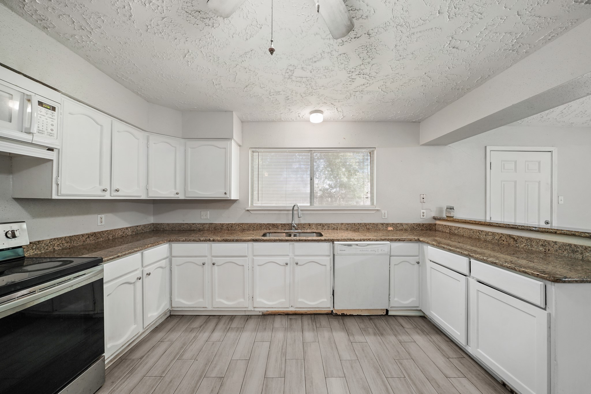 13923 Ludgate Pass Houston, TX 77034 - Photo 11 of 25 a kitchen with granite countertop white cabinets and white appliances