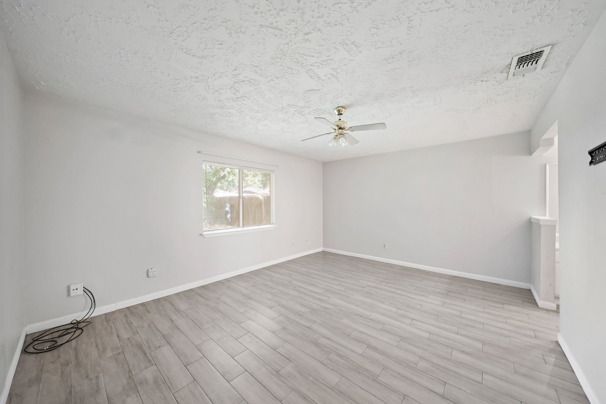 13923 Ludgate Pass Houston, TX 77034 - Photo 16 of 25 a view of an empty room with a window and wooden floor