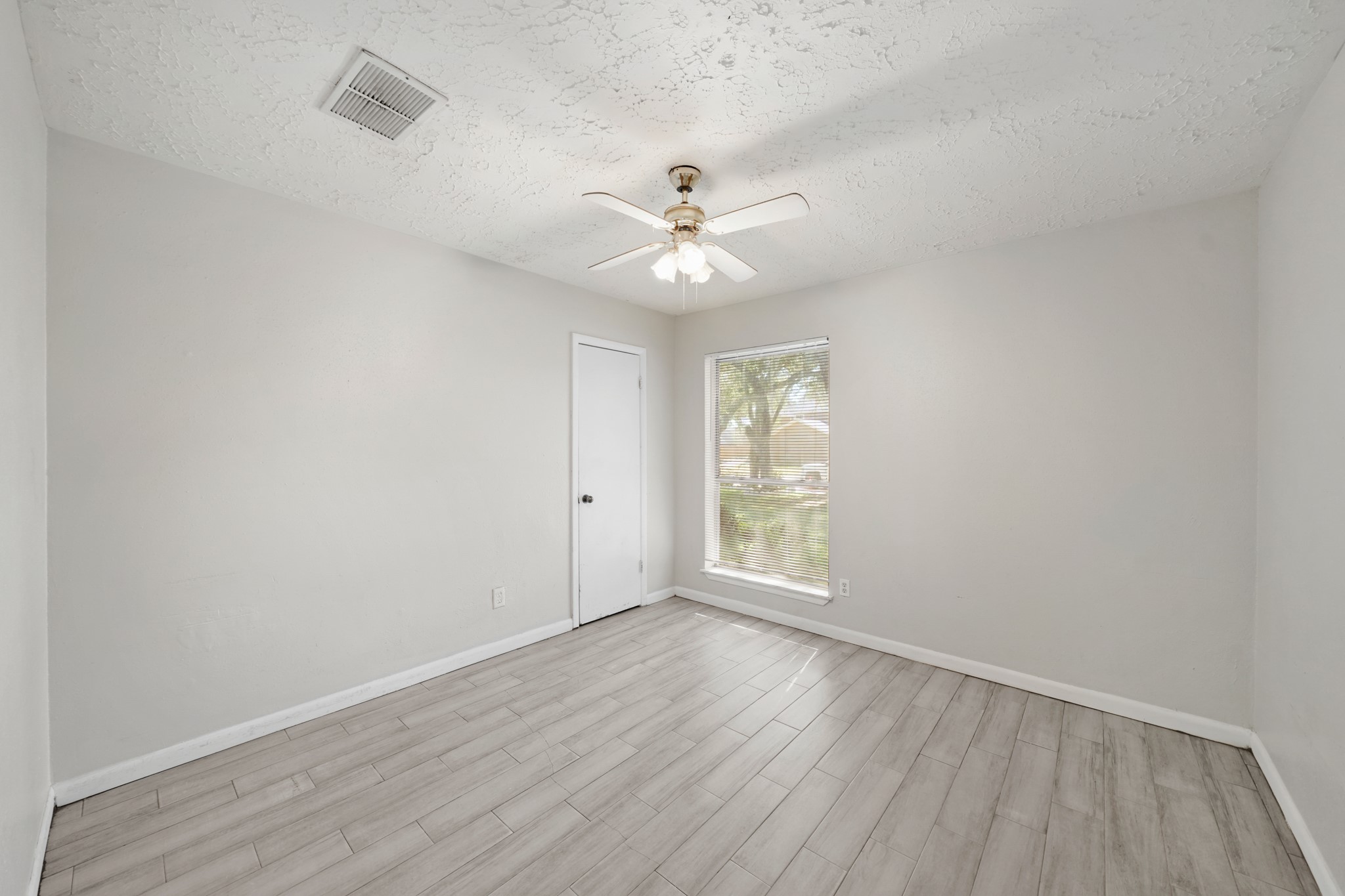 13923 Ludgate Pass Houston, TX 77034 - Photo 19 of 25 an empty room with wooden floor and windows