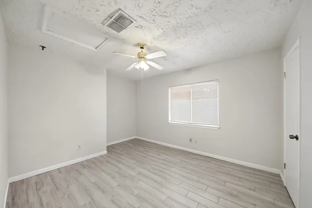 an empty room with wooden floor and window