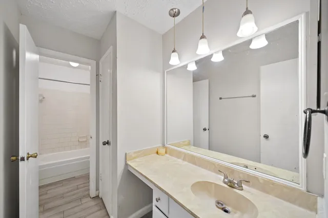 a bathroom with a sink a light fixture and a mirror