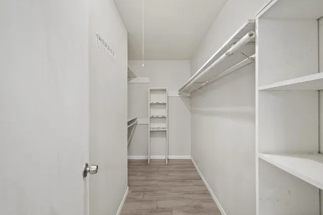 a view of a hallway with closet and a window