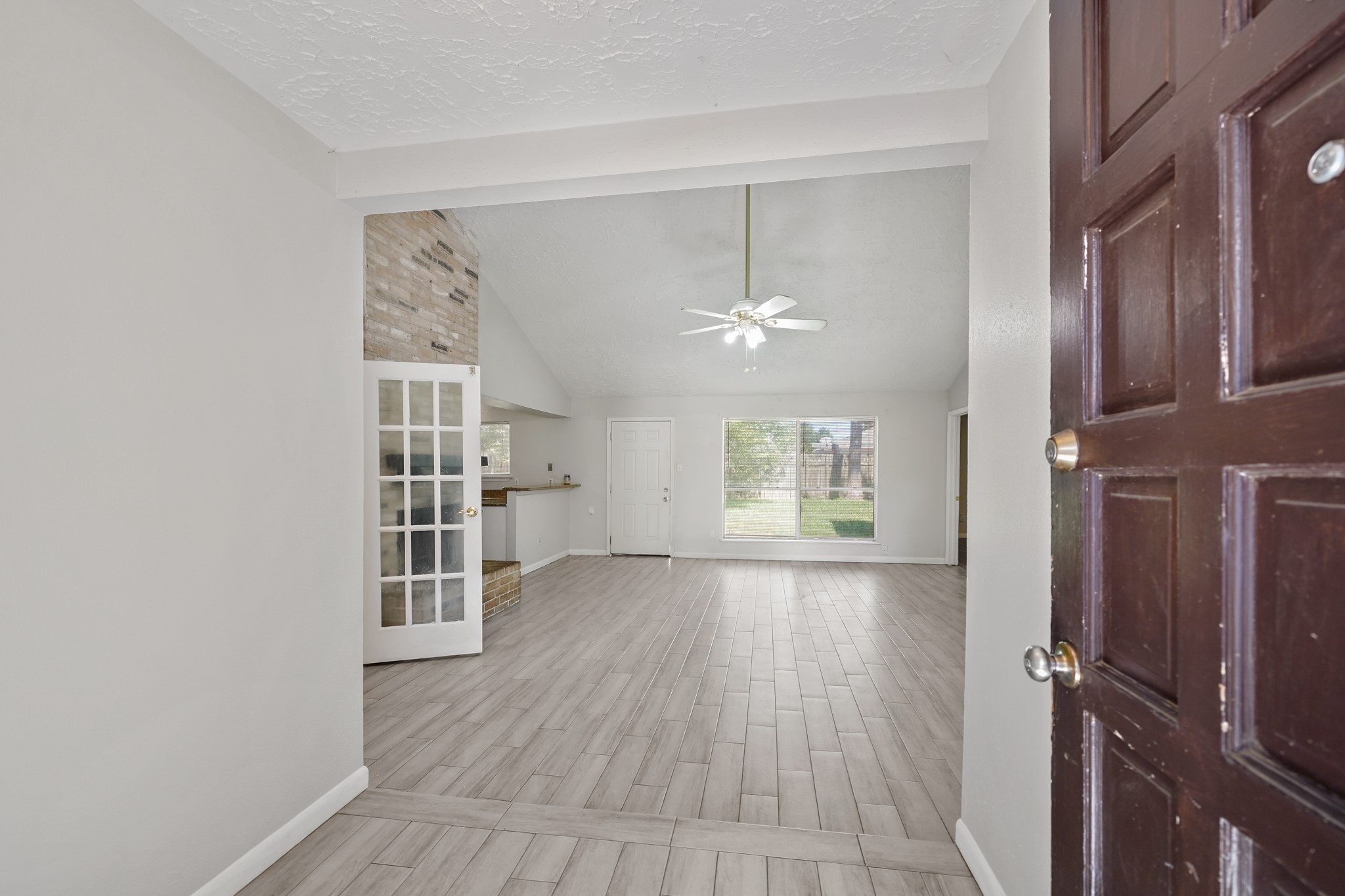 13923 Ludgate Pass Houston, TX 77034 - Photo 4 of 25 an empty room with wooden floor cabinet and windows