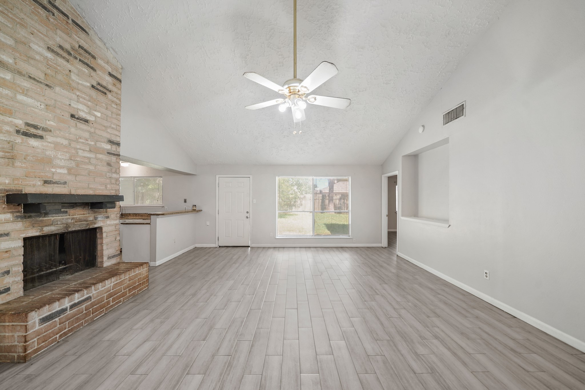 13923 Ludgate Pass Houston, TX 77034 - Photo 6 of 25 an empty room with windows and a fireplace