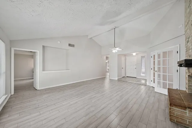 a view of empty room with wooden floor and window