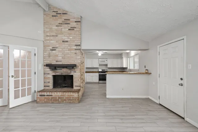 a view of kitchen with granite countertop stove top oven and cabinets