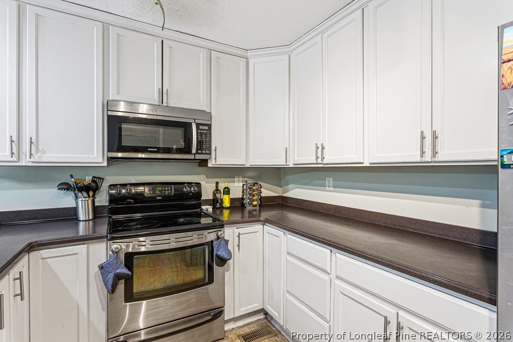 461 Lands End Road Fayetteville, NC 28314 - Photo 7 of 31 a kitchen with granite countertop white cabinets and stainless steel appliances
