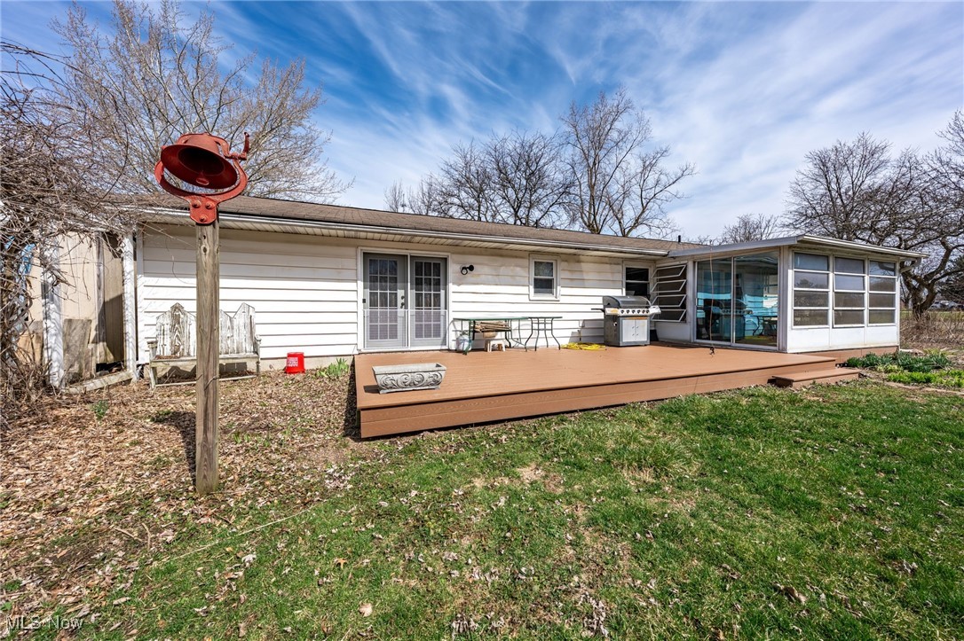4790 Paradise Road Seville, OH 44273 - Photo 11 of 45 Back of property featuring a sunroom, a wooden deck, french doors, and a yard