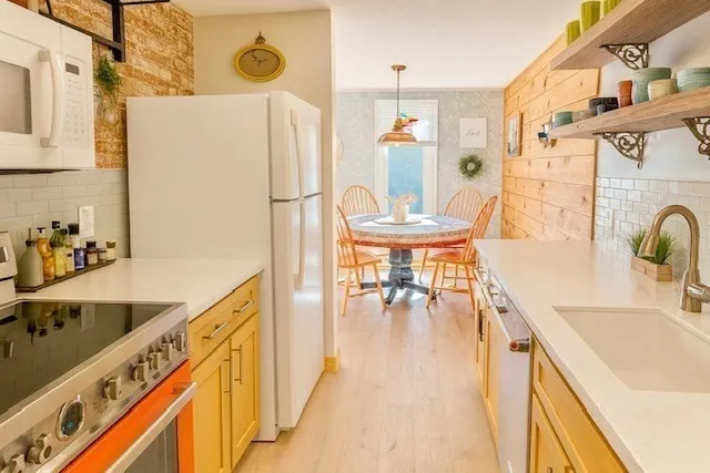 a kitchen with stainless steel appliances a stove a chimney and a refrigerator