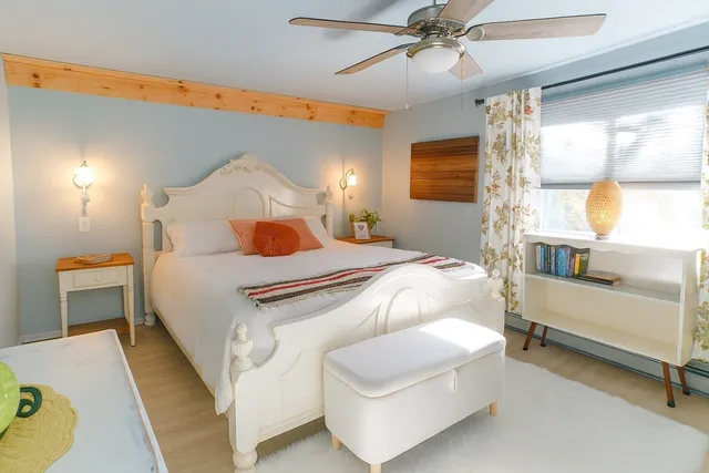 a bedroom with a bed a chandelier and a dresser