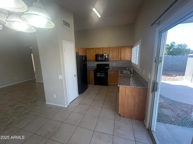 a kitchen with kitchen island granite countertop a refrigerator and a sink