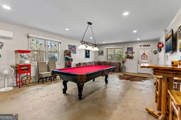 a room with stainless steel appliances kitchen island granite countertop furniture a rug and a window