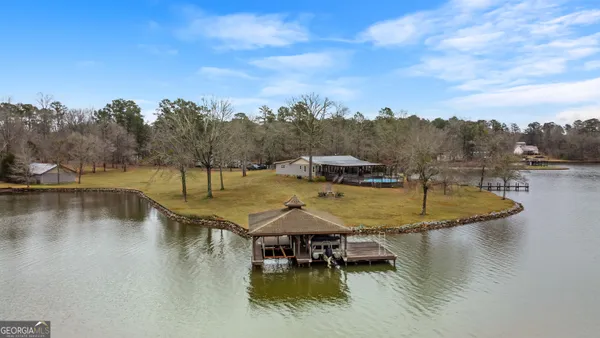 a view of a swimming pool with a patio and a yard