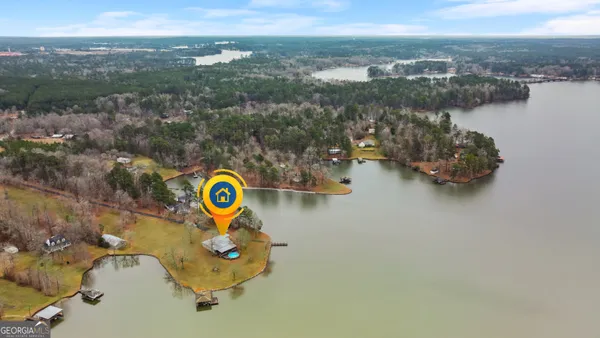 an aerial view of a swimming pool with a yard and lake view
