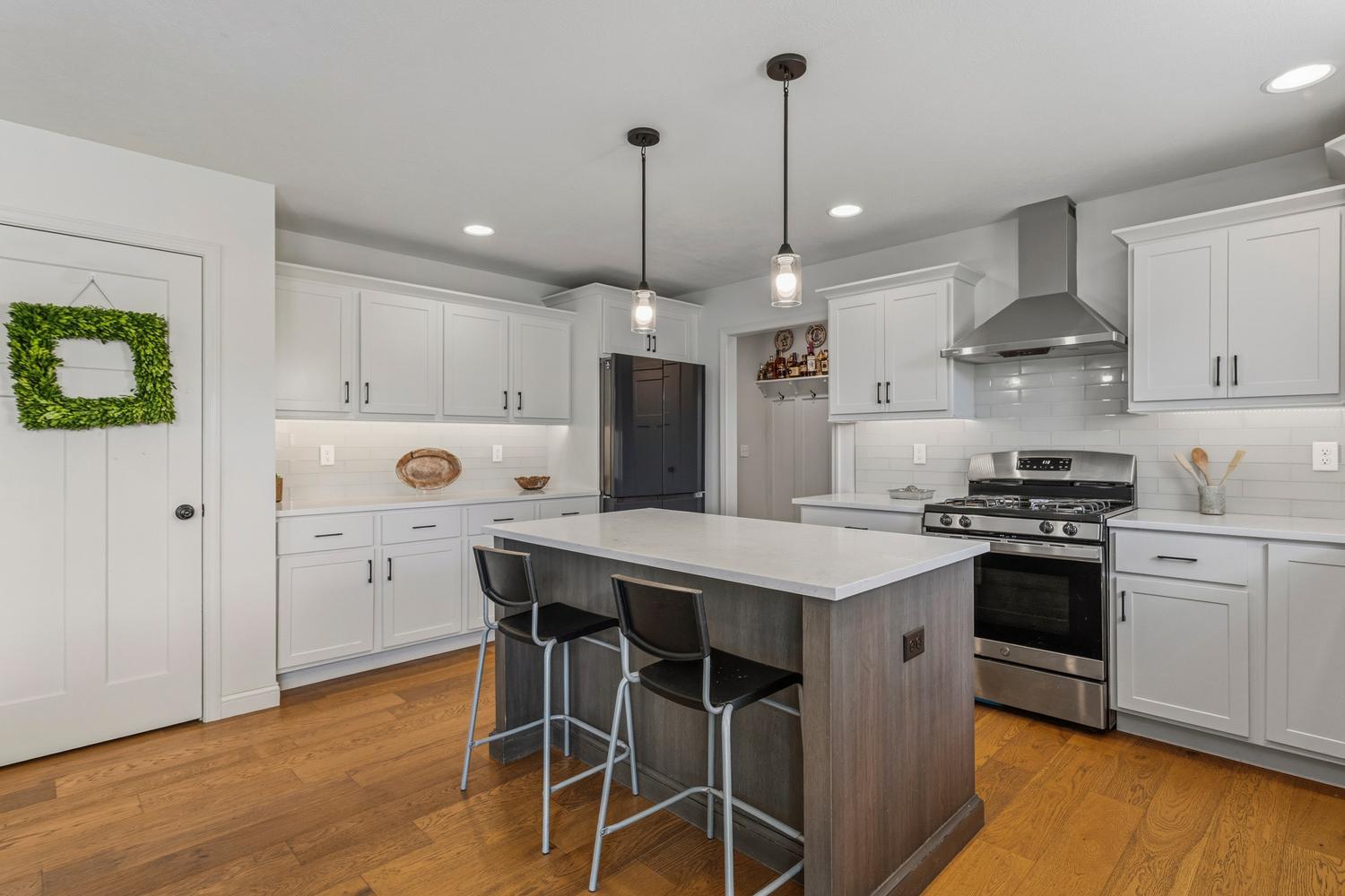718 Cole Lane Mahomet, IL 61853 - Photo 14 of 44 a kitchen with a stove a refrigerator and a wooden floor