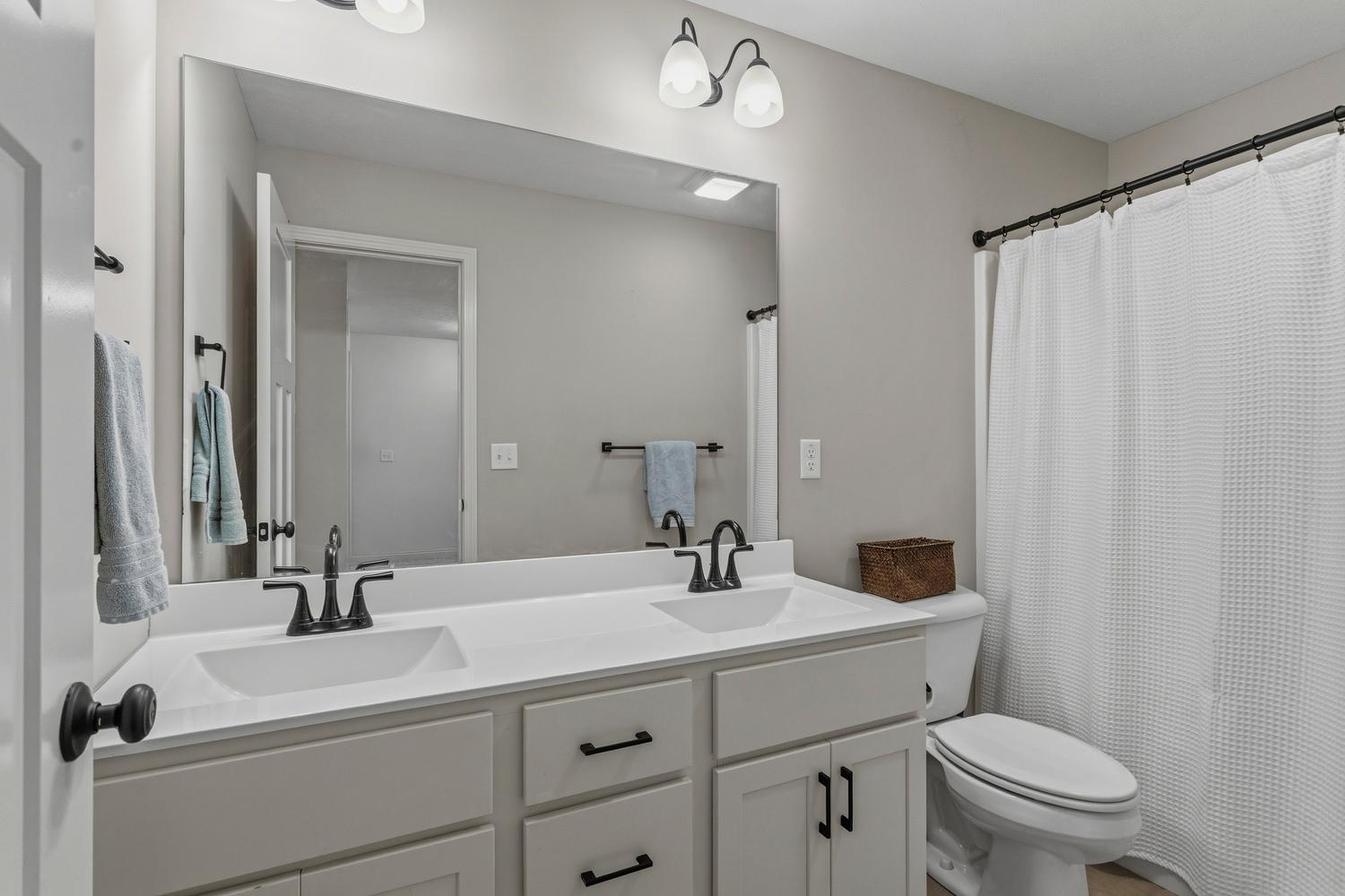 718 Cole Lane Mahomet, IL 61853 - Photo 29 of 44 a bathroom with a sink toilet a mirror and shower curtain