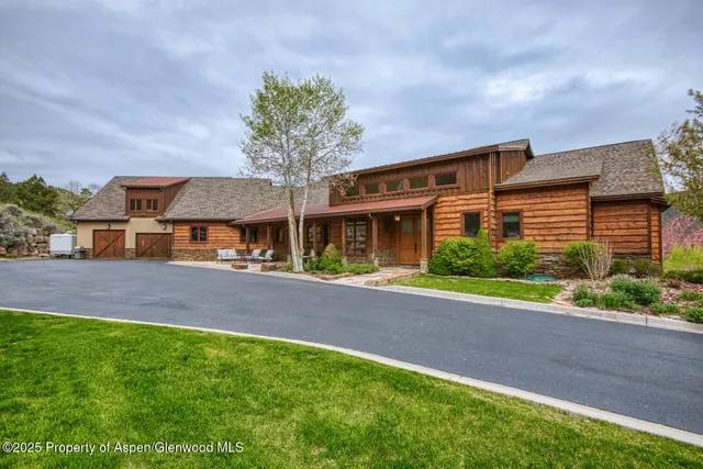 a front view of a house with a yard and potted plants