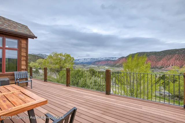 a view of a balcony with wooden floor and fence