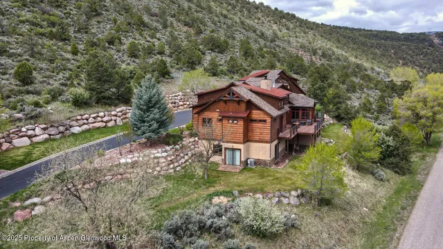 an aerial view of a house with a big yard and large trees