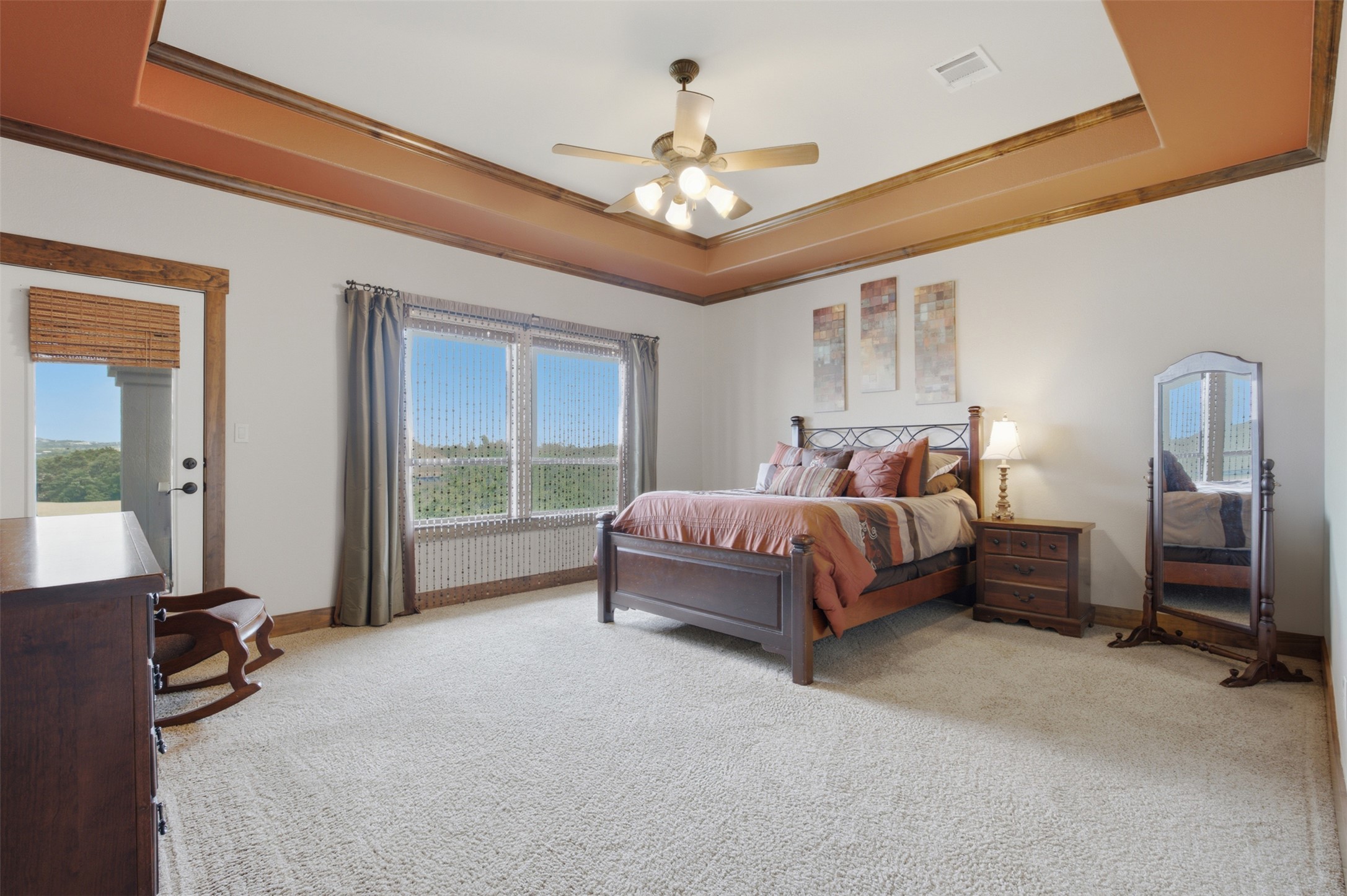 700 Augusta Circle Point Venture, TX 78645 - Photo 8 of 35 A spacious primary bedroom features a striking tray ceiling and abundant natural light.