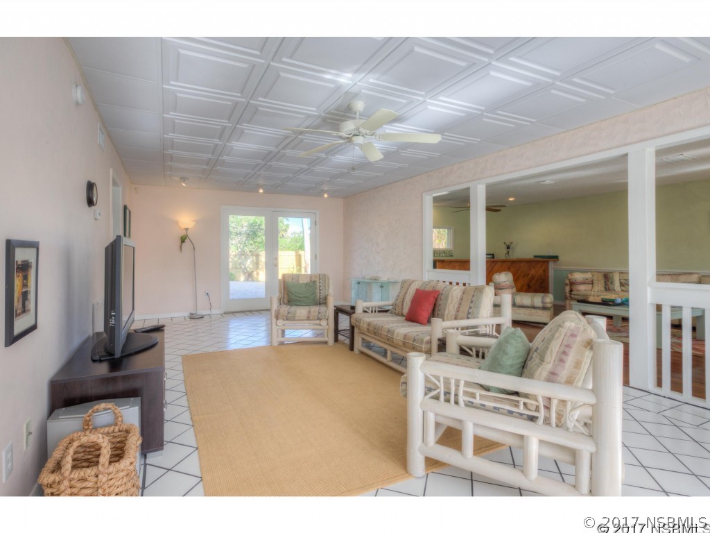 6455 Engram Road New Smyrna Beach, FL 32169 - Photo 14 of 33 a living room with furniture a flat screen tv and a large window