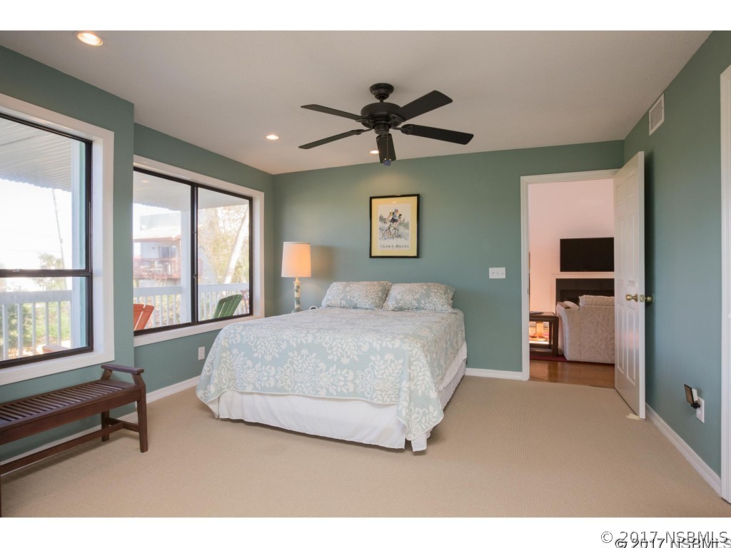 6455 Engram Road New Smyrna Beach, FL 32169 - Photo 24 of 33 a bedroom with a large bed and a chandelier