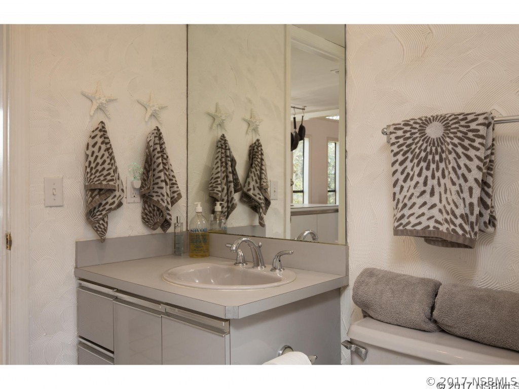 6455 Engram Road New Smyrna Beach, FL 32169 - Photo 26 of 33 a bathroom with a granite countertop sink a mirror and shower