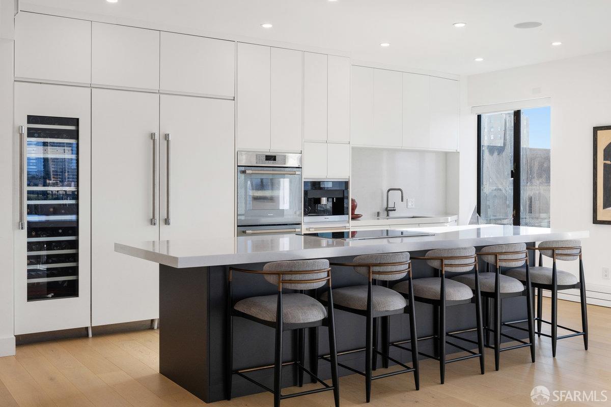 1170 Sacramento Street, Unit 9C San Francisco, CA 94108 - Photo 23 of 32 a kitchen with stainless steel appliances kitchen island granite countertop a table chairs sink and cabinets