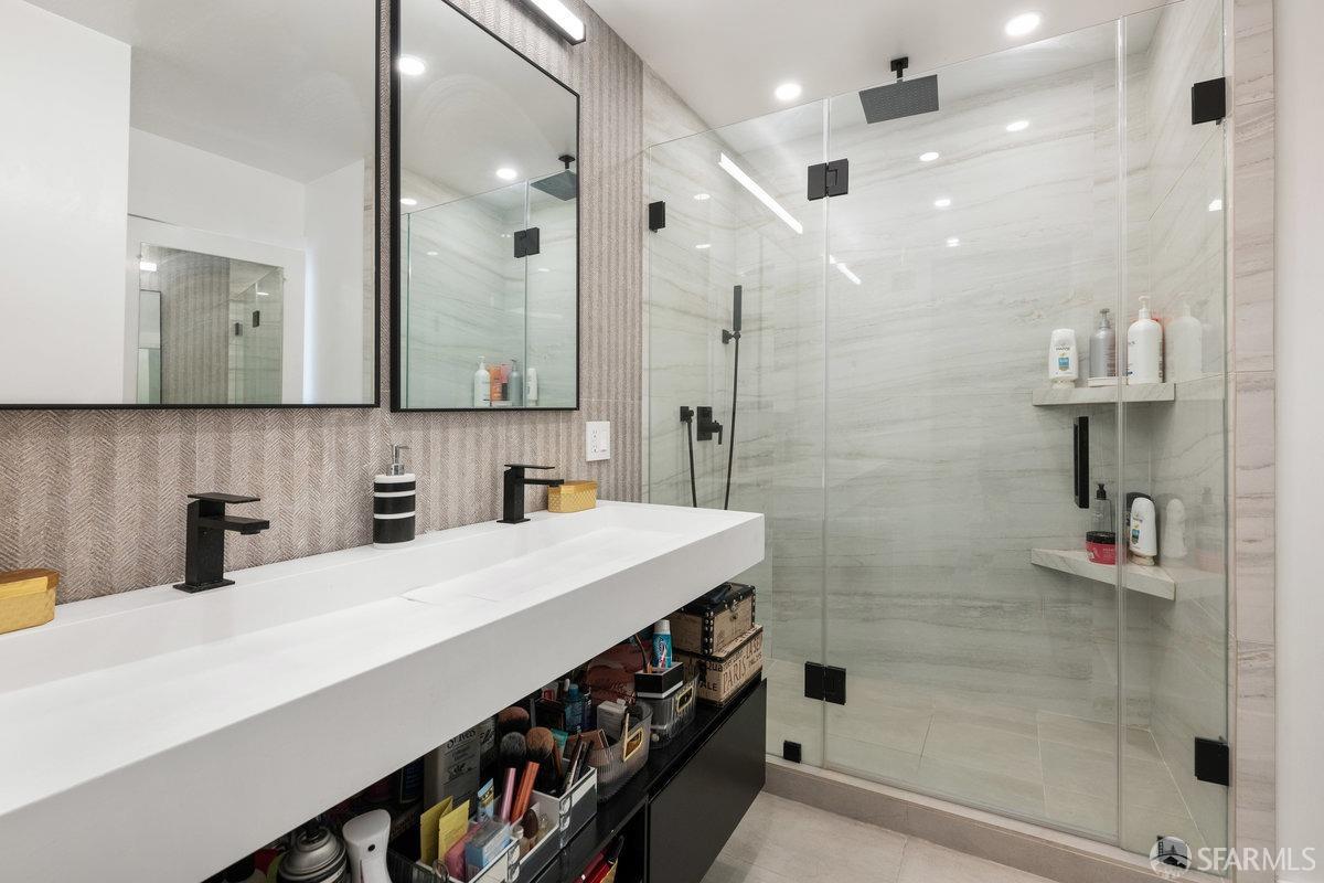 1170 Sacramento Street, Unit 9C San Francisco, CA 94108 - Photo 28 of 32 a bathroom with a sink a large mirror and shower