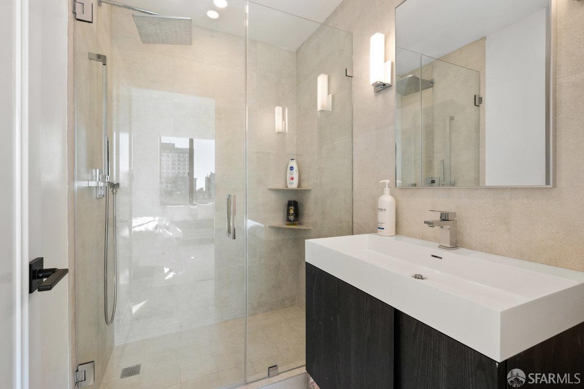 1170 Sacramento Street, Unit 9C San Francisco, CA 94108 - Photo 30 of 32 a bathroom with a sink a toilet a shower and a mirror