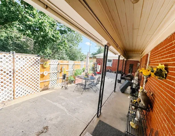 a view of a patio with table and chairs and floor to ceiling window