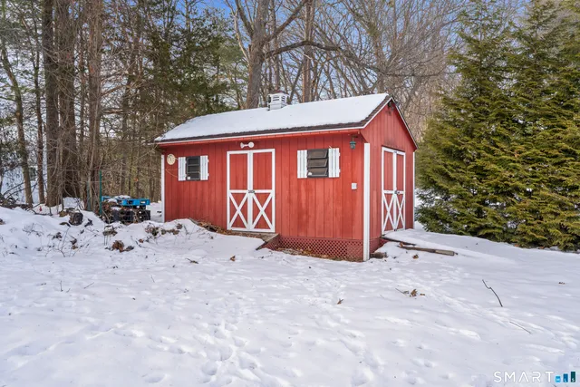 a view of backyard with a barn and large trees