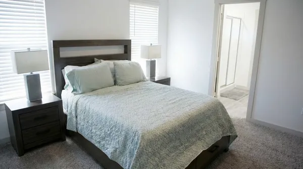 a large bed sitting in a bedroom next to a window