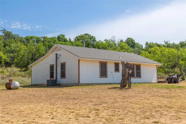 a living room with furniture a ceiling fan and a large window