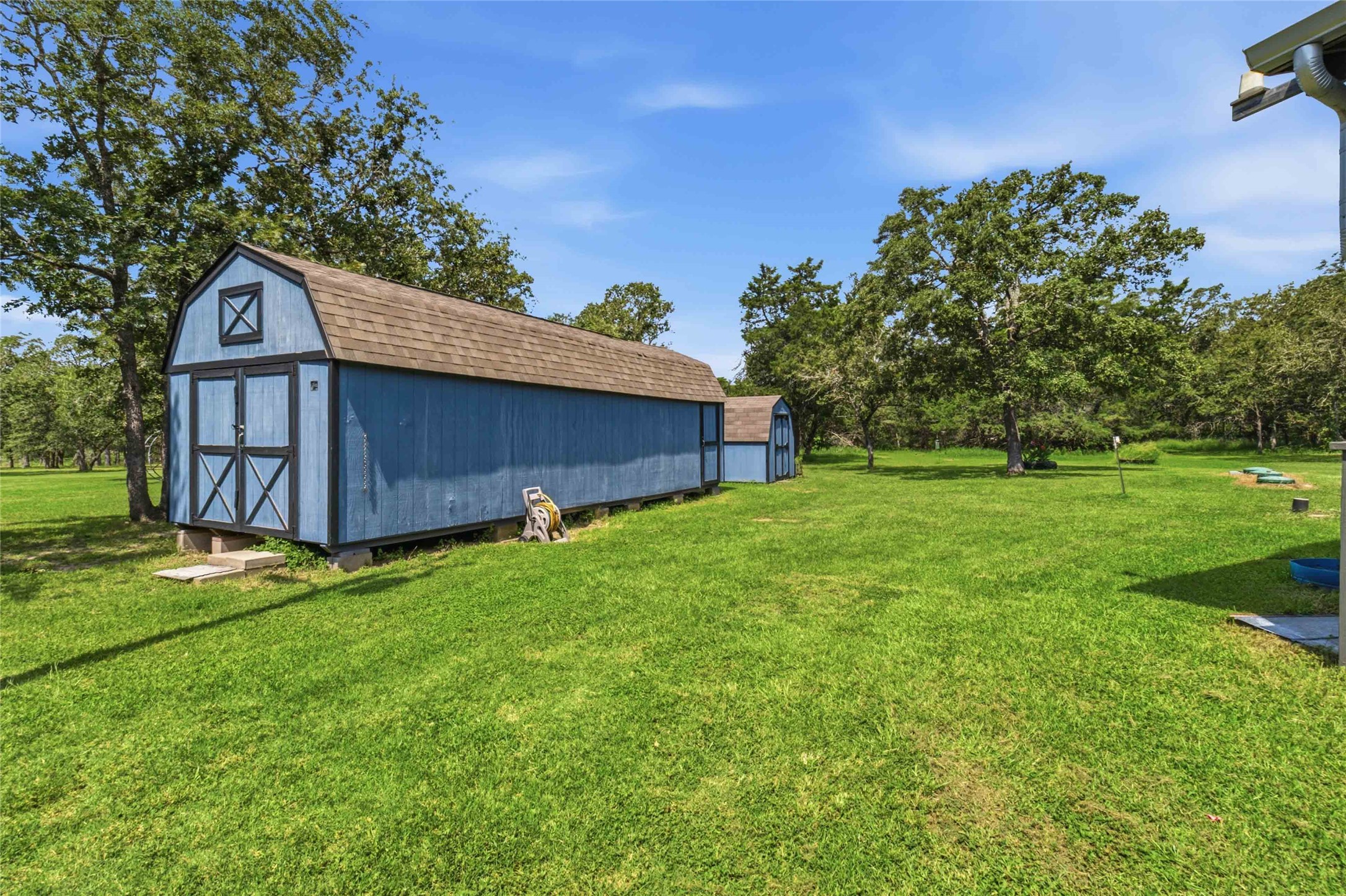 7921 Vista Ranch Road Smithville, TX 78957 - Photo 23 of 39 A spacious yard with verdant grass, mature trees, and a practical storage shed.