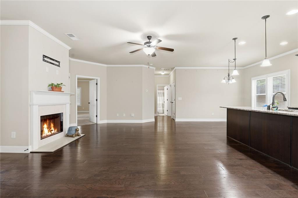 163 Hawthorne Ridge Circle Dallas, GA 30132 - Photo 13 of 50 a view of a kitchen with a fireplace a ceiling fan and wooden floor