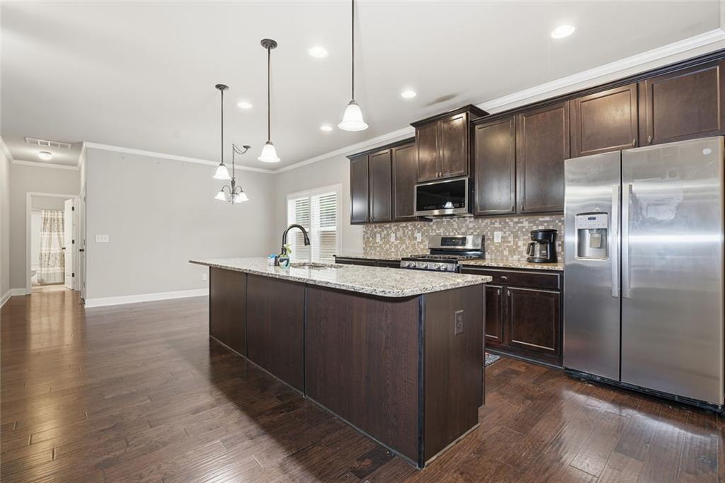 163 Hawthorne Ridge Circle Dallas, GA 30132 - Photo 19 of 50 a kitchen with kitchen island a counter space a sink appliances and cabinets