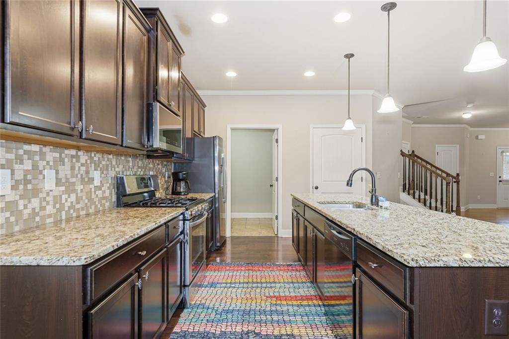 163 Hawthorne Ridge Circle Dallas, GA 30132 - Photo 20 of 50 a kitchen with stainless steel appliances granite countertop a sink a stove and a wooden floor