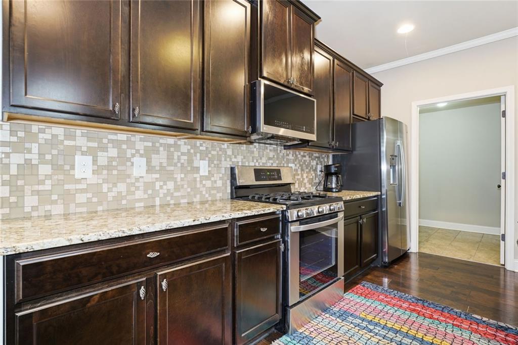163 Hawthorne Ridge Circle Dallas, GA 30132 - Photo 21 of 50 a kitchen with stainless steel appliances granite countertop a stove a sink and a refrigerator