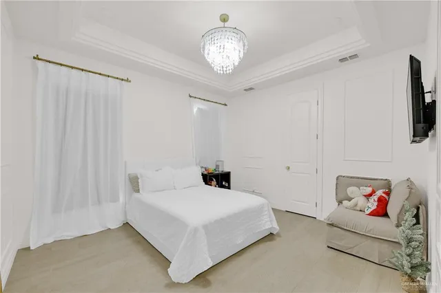 a bedroom with a bed and a chandelier