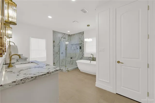 a bathroom with a granite countertop sink mirror and bathtub