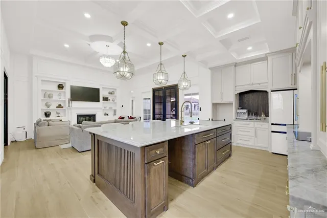 a large kitchen with kitchen island a sink stainless steel appliances and chandelier